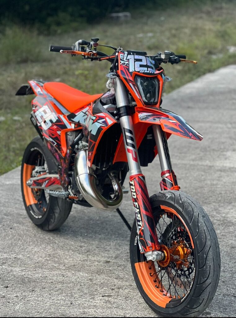 KTM 125 factory Mattia Amorosi kit grafiche – Personalizzazione Estrema per SX, EXC, Duke e Freeride🧡 Ktm 125 factory Mattia Amorosi grafiche professionali per modelli SX, SX-F, EXC, EXC-F, Freeride e Duke Se cerchi un kit di grafiche Ktm 125 Factory Mattia Amorosi  capace di unire design estremo, resistenza professionale e massima personalizzazione, allora Ktm 125 Factory Mattia Amorosi   è la scelta che fa per te. Un concentrato di stile e performance pensato per trasformare completamente il look della tua moto, sia che tu corra in pista, in enduro o semplicemente voglia distinguerti con un’estetica mozzafiato. ✅ Compatibilità garantita Il Kit Grafiche Ktm 125 Factory Mattia Amorosi   è disponibile per tutti i principali modelli: KTM SX / SX-F (tutti gli anni) KTM EXC / EXC-F KTM Freeride KTM Duke 125 / 390 / 690 e altre cilindrate Basta selezionare il tuo modello al momento dell’ordine e penseremo noi a realizzare il kit su misura per la tua moto.